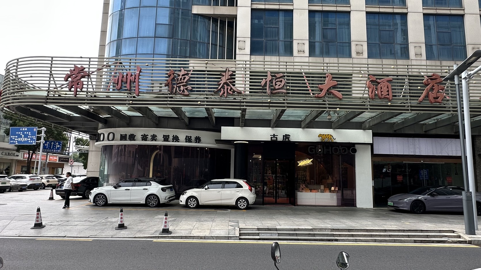 常州德泰恒大酒店建築外牆上的紅色大字招牌「常州德泰恒大酒店」，樓下停著數輛汽車