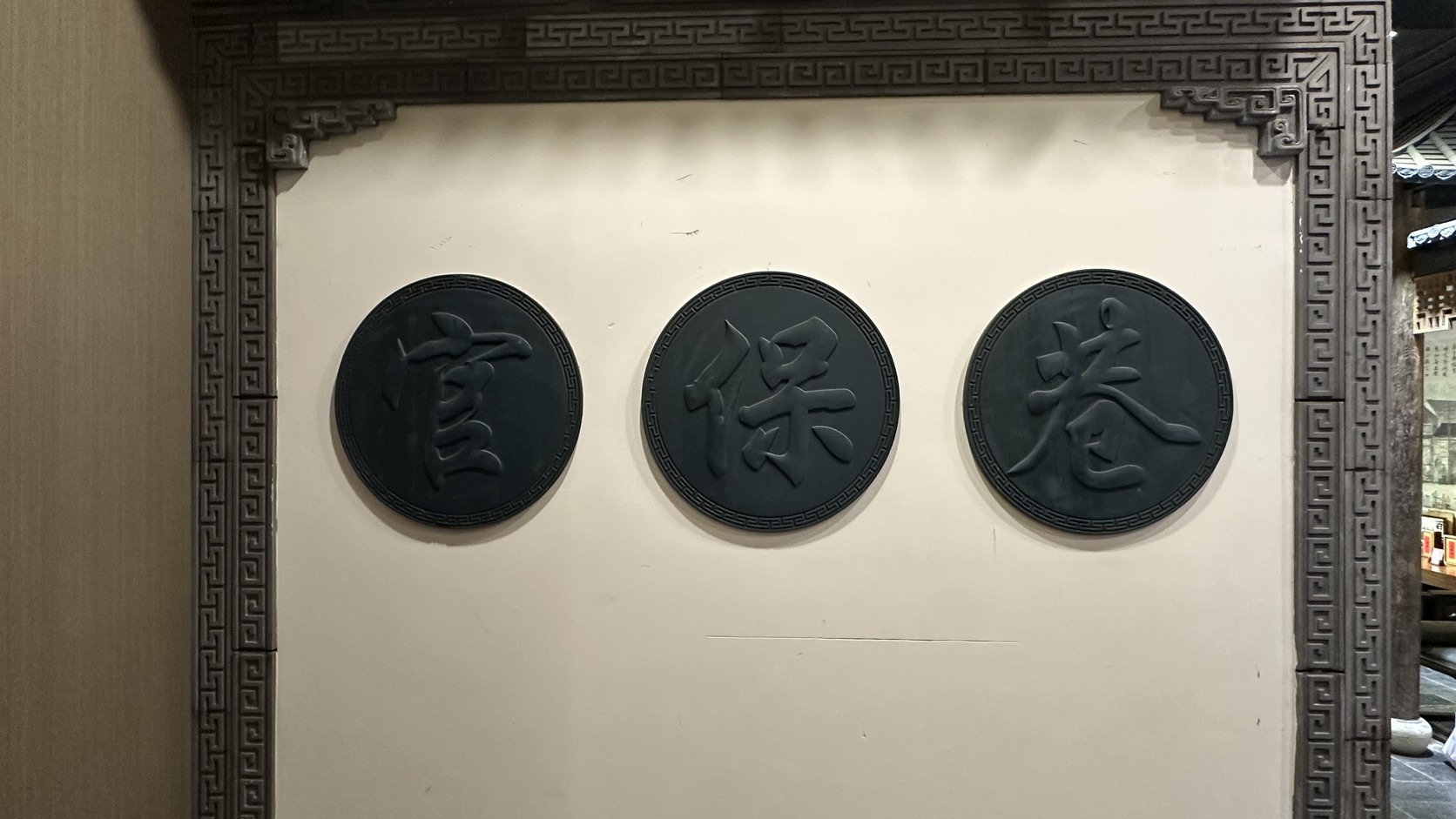 牆上三個圓形牆飾，分別刻著「官」「保」「巷」三個字