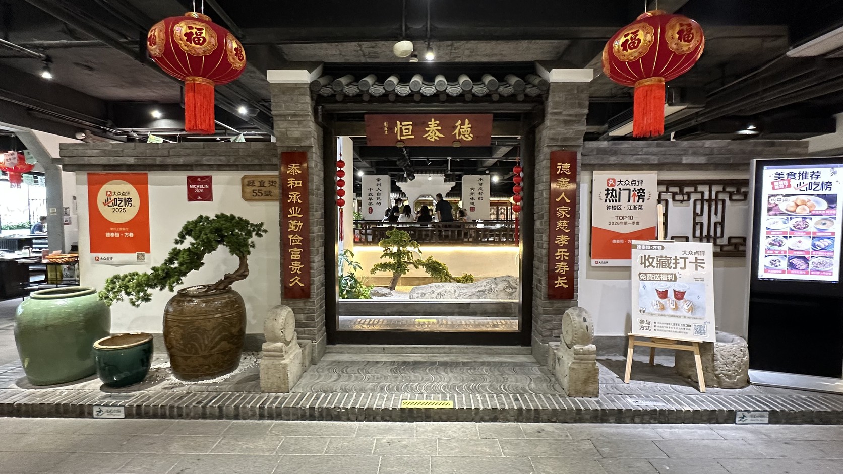 二樓的「德泰恒」門樓，門前擺著盆景與陶缸，兩側貼著紅色對聯