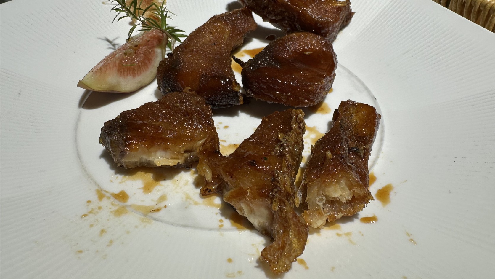 爆魚近照，魚塊切面可見魚皮與魚肉連成一整塊的酥脆結構，沾著醬汁