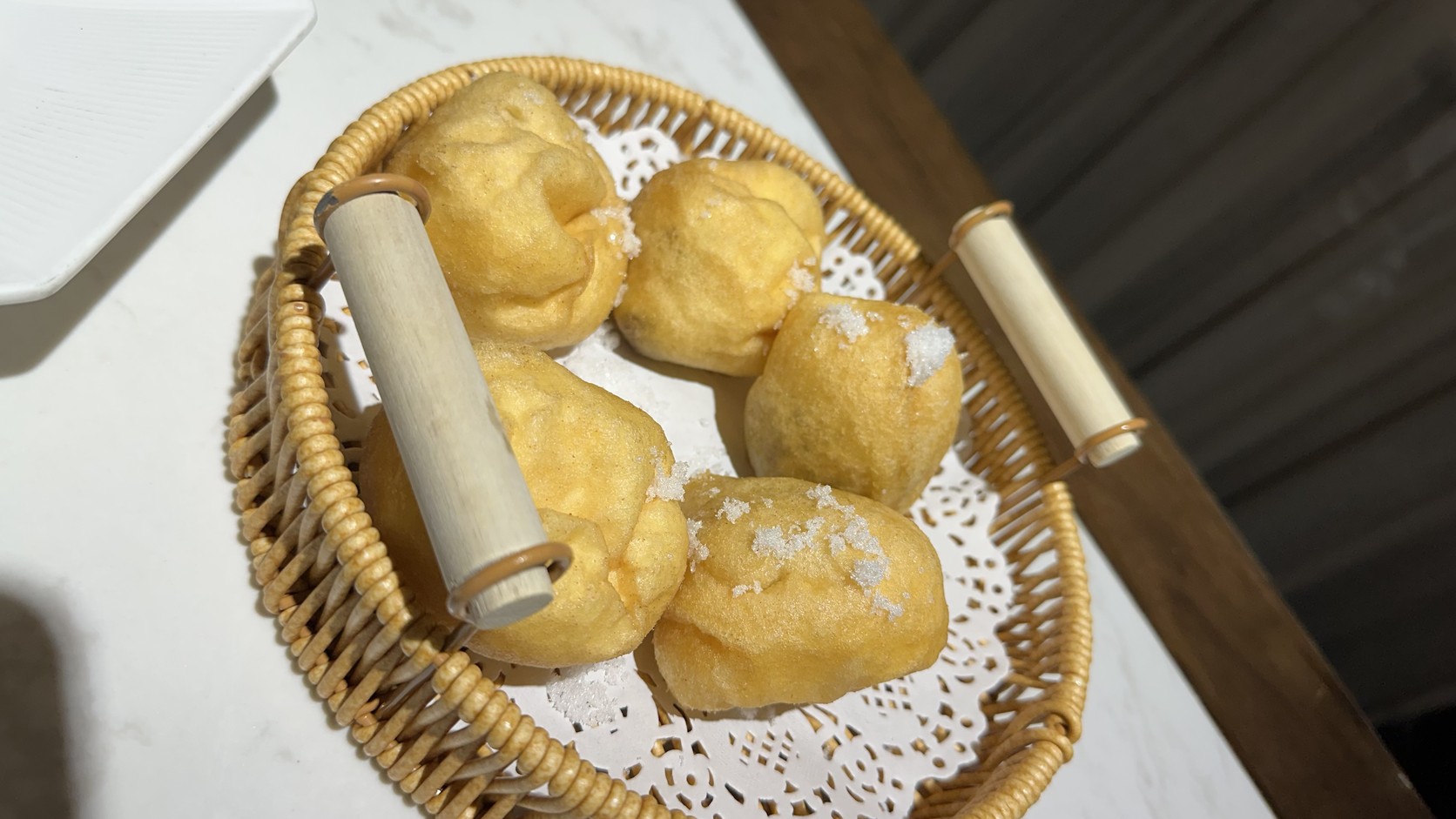 竹籃裡的孝子網油卷，表面撒著白糖，墊著鏤空墊紙