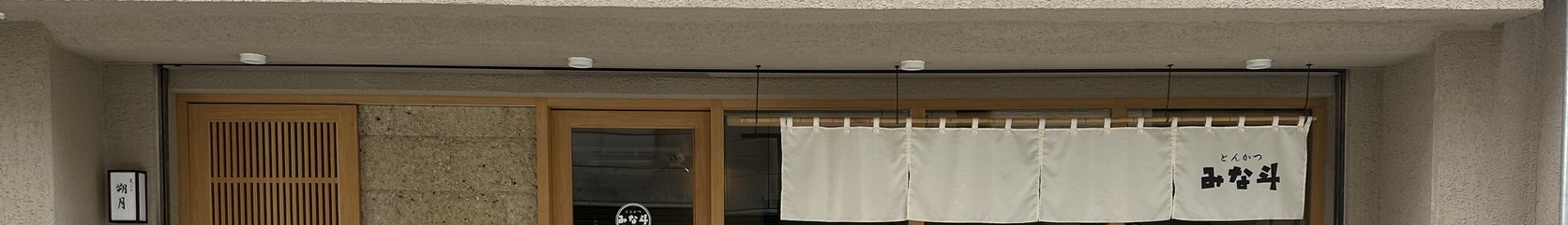 「とんかつ みな斗」店面外觀，白色暖簾上寫著「とんかつ みな斗」，旁邊是木質門窗與入口