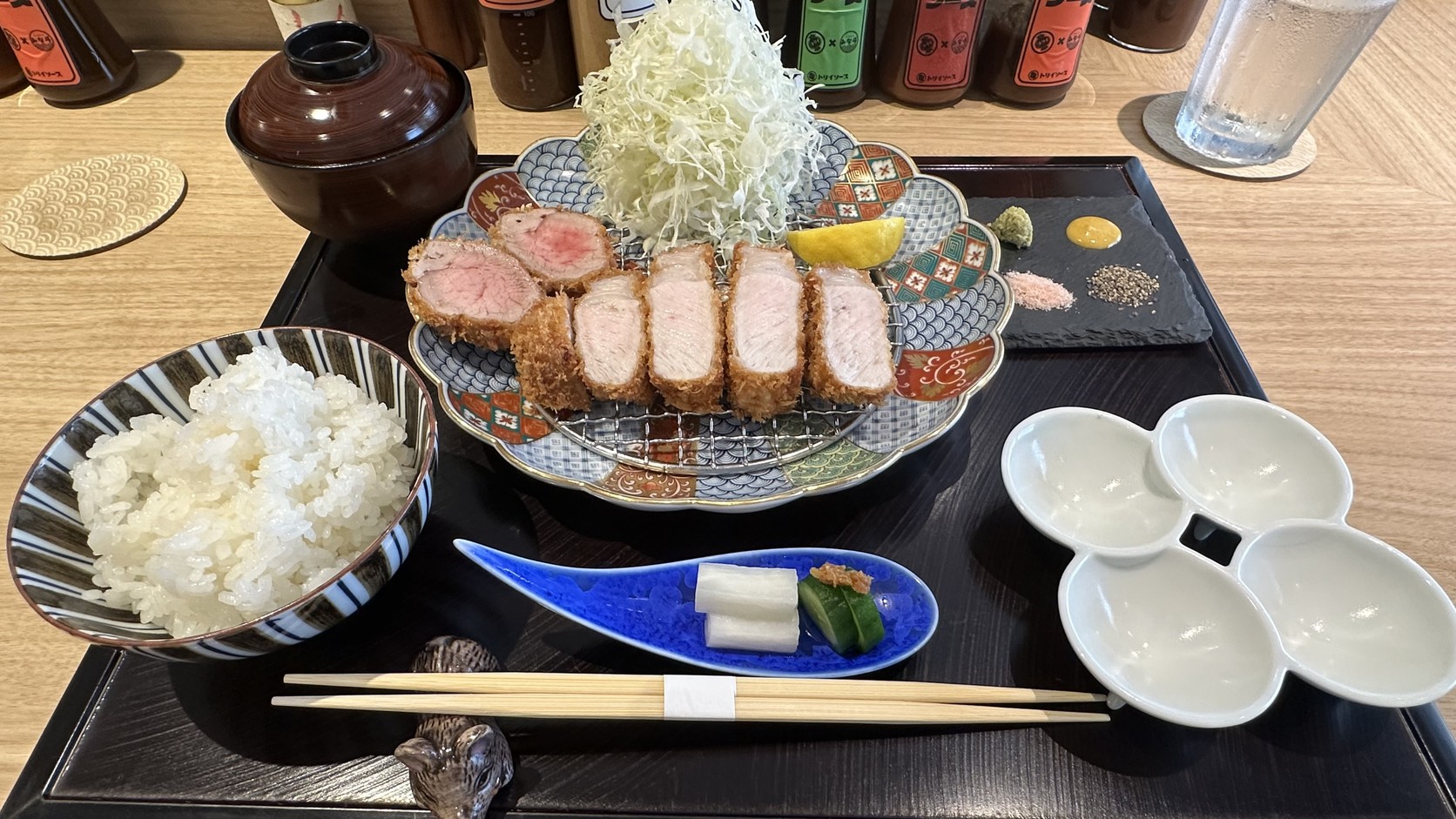 鹿兒島黑豚里肌與明神豚菲力的綜合套餐，炸豬排切開盛在鐵網上，旁邊有高麗菜絲、白飯、漬物、調味石板與四格小盤