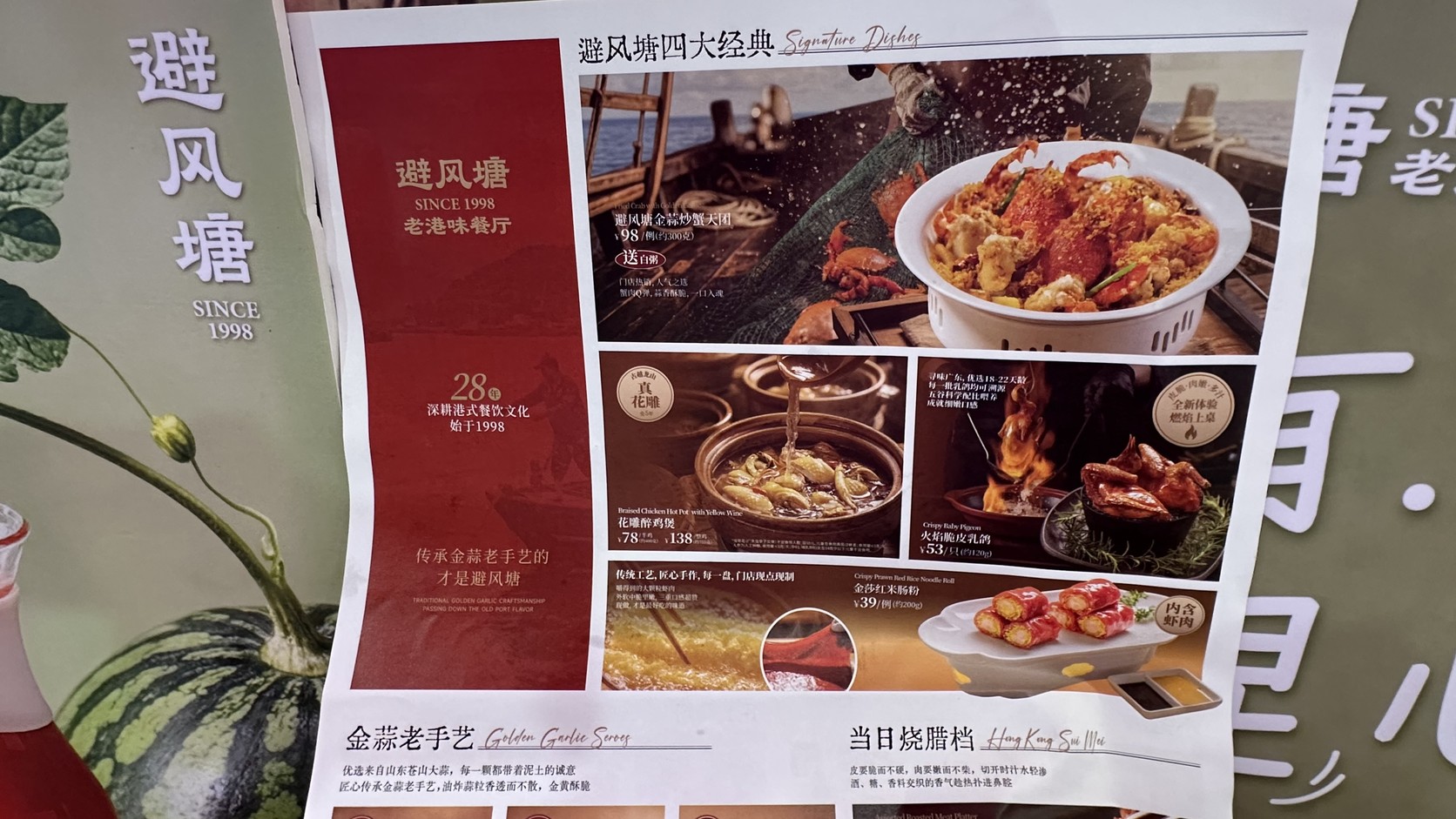 避風塘菜單「四大經典」頁實拍，列出金蒜炒蟹天團、花雕醉雞煲、火焰脆皮乳鴿與金莎紅米腸粉的價格與份量