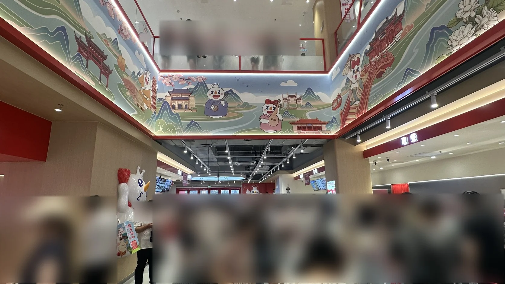 旗艦店一樓大廳：挑高牆面畫滿南京風景與雪王，排隊點餐與等待取餐的人潮擠滿大廳（人潮已模糊）