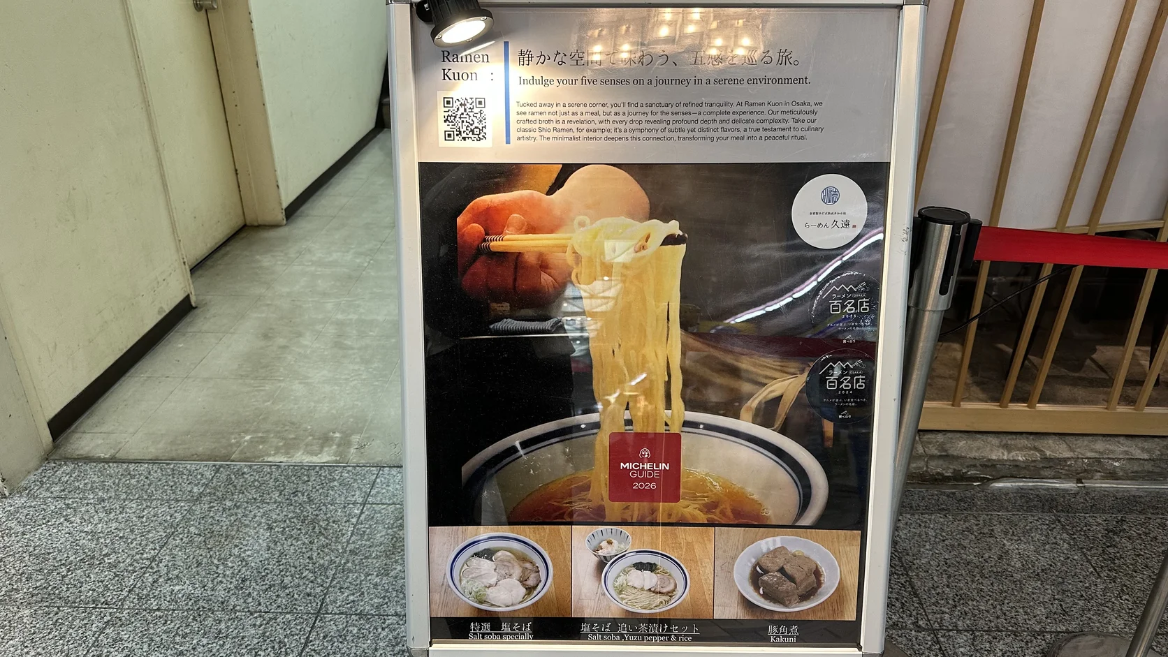 店外立牌：印有 Ramen Kuon 簡介、MICHELIN GUIDE 2026 標示與細麵特寫，下方列出特選塩そば、塩そば追い茶漬けセット與豚角煮