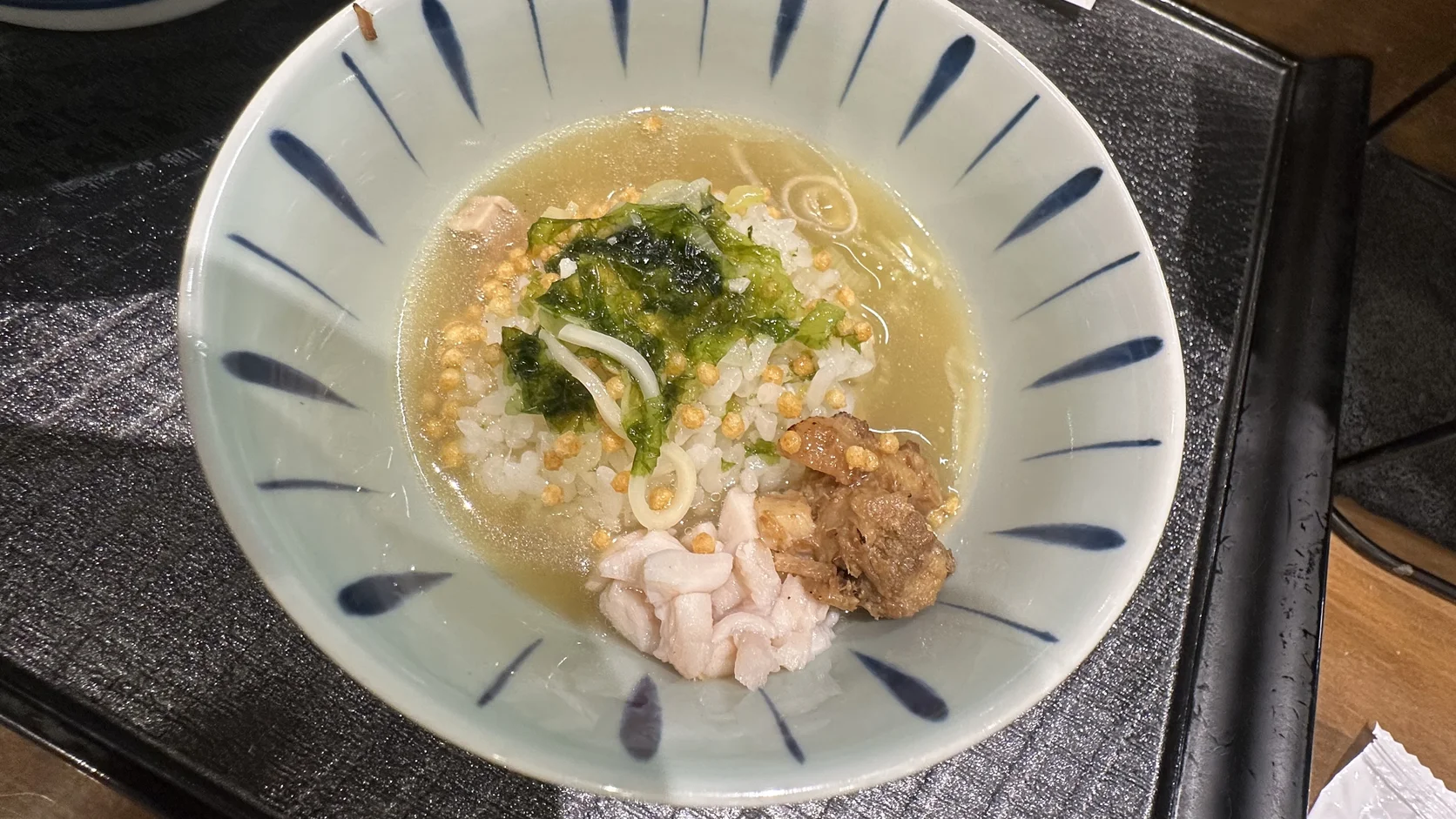 拉麵湯汁加入小飯碗後的茶泡飯，白飯、米果、海苔與碎肉浸在湯裡