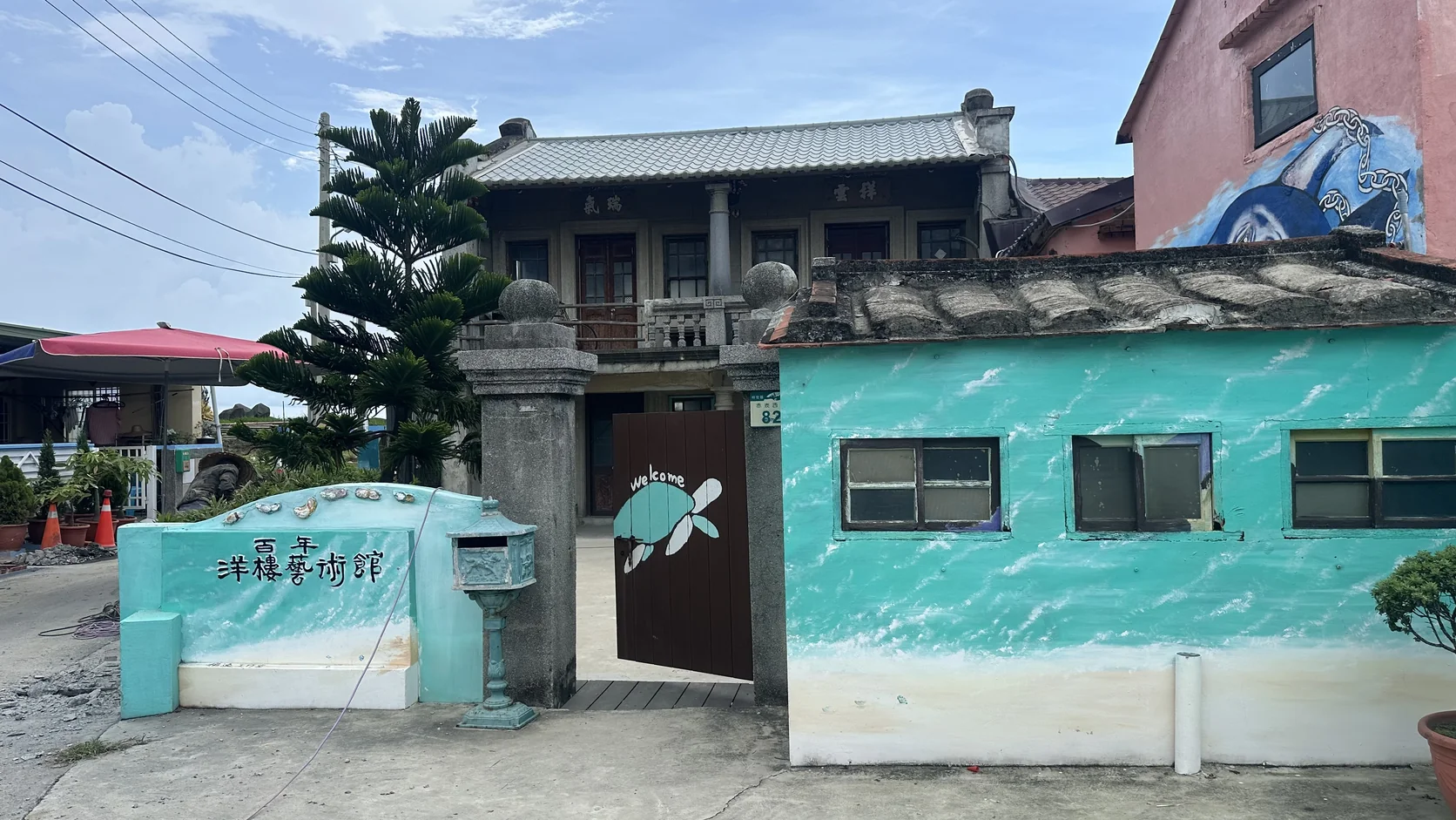 百年洋樓藝術館所在的劉德波洋樓，前方有海龜彩繪，旁邊保留舊式房屋