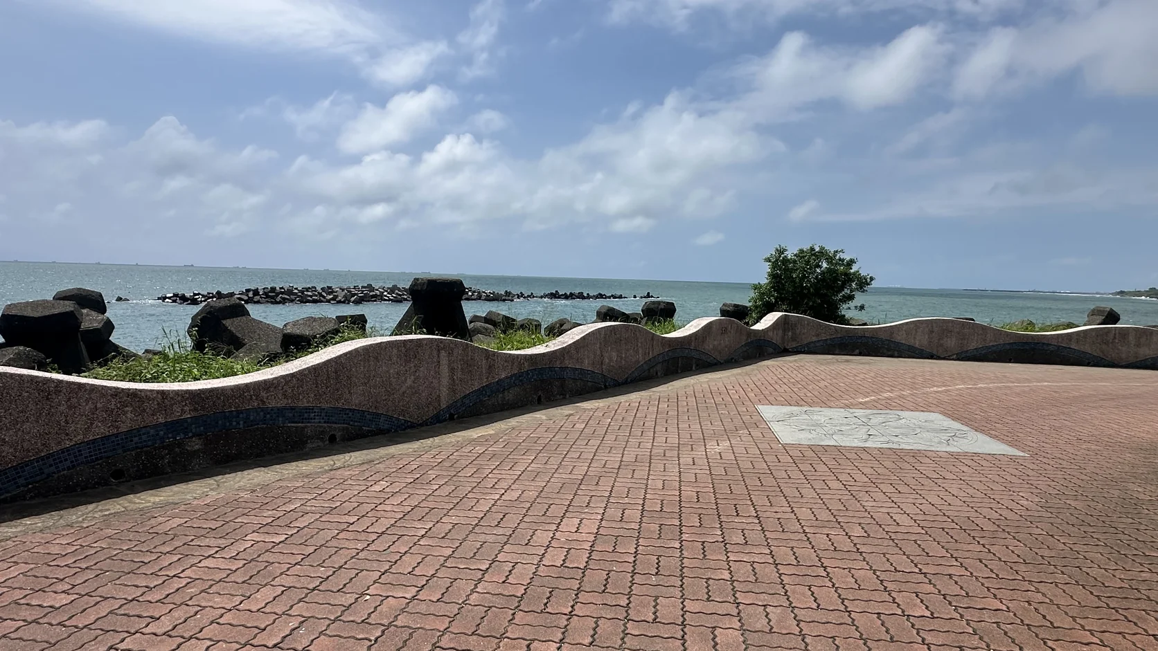 赤崁海濱的紅磚廣場與波浪造型矮牆，後方是臺灣海峽