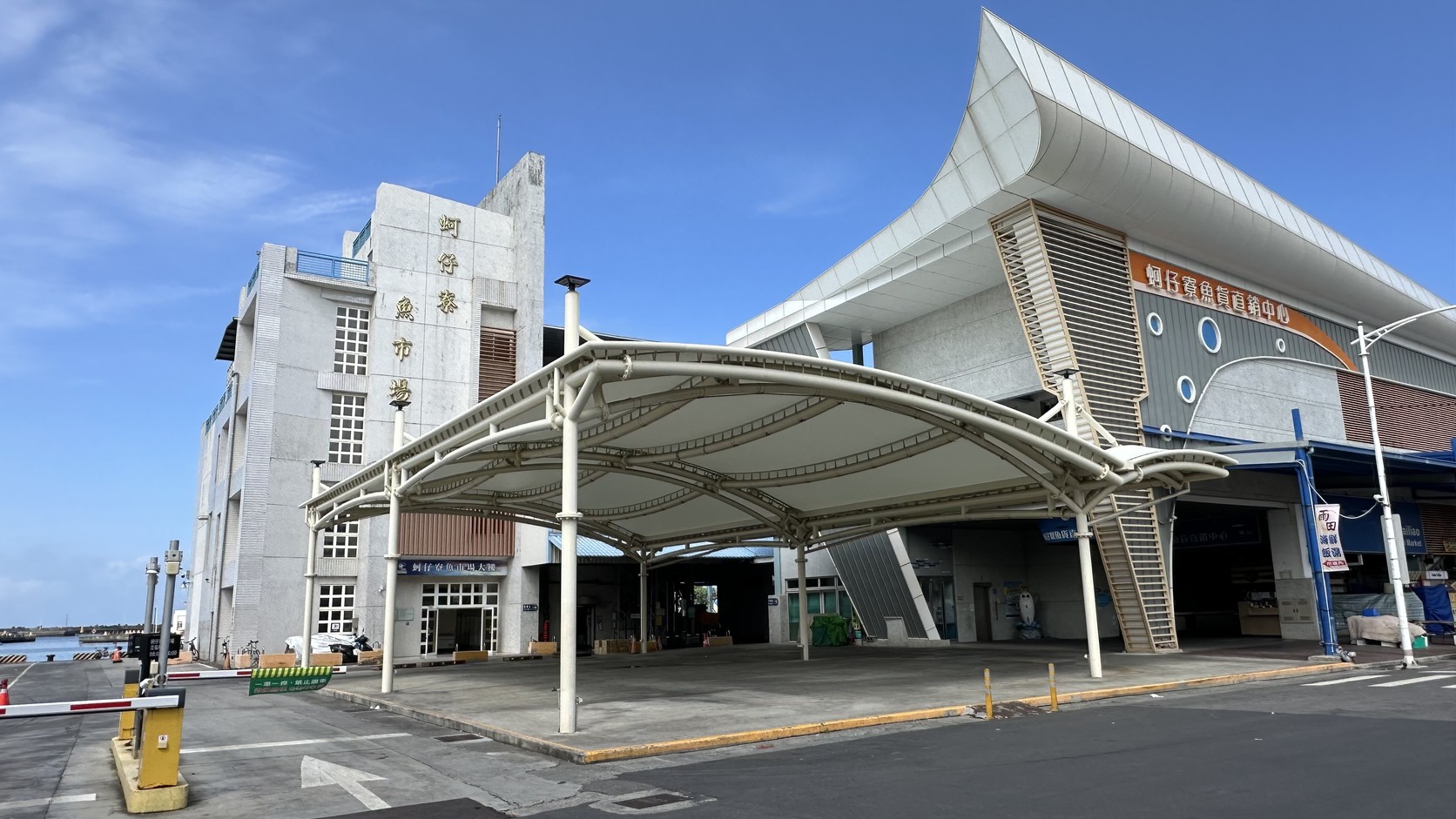 蚵仔寮魚市場特色圖：白色帆形屋頂的魚貨直銷中心建築外觀與入口雨棚