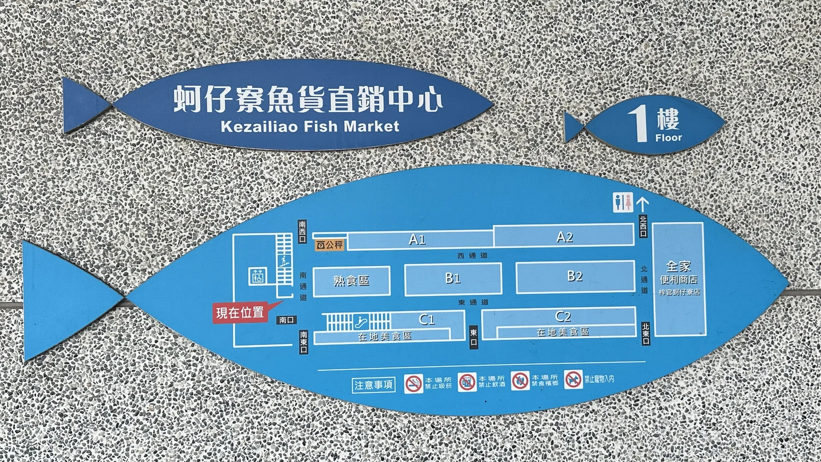 蚵仔寮魚貨直銷中心一樓魚形平面圖，標示 A1 至 C2 攤位區、熟食區、在地美食區、公秤、全家便利商店與廁所