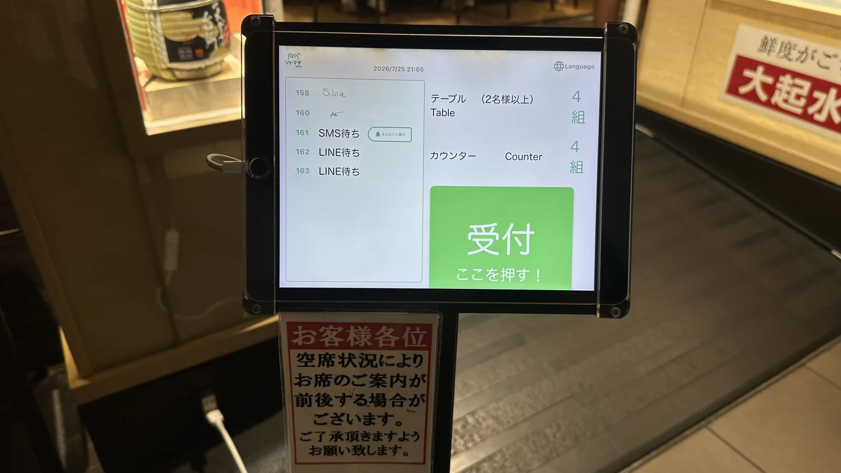 店門口的候位機首頁，畫面上有綠色的「受付」按鈕