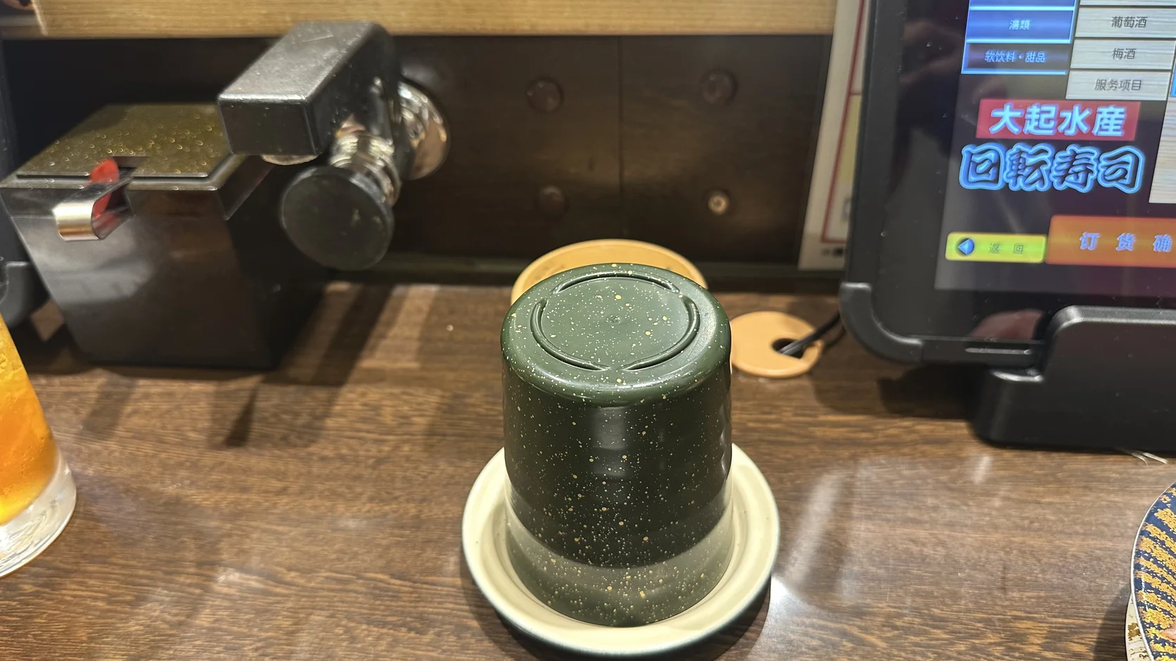 桌邊的綠色茶杯與自助熱水出口