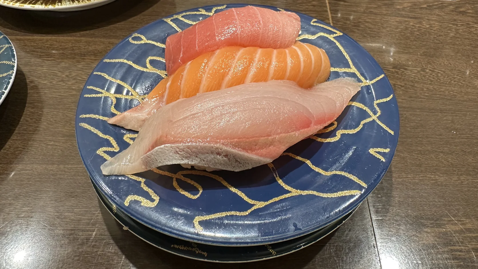 本鮪中腹、鰤魚腹身與鮭魚腹組成的三貫拼盤，疊在兩層盤子上