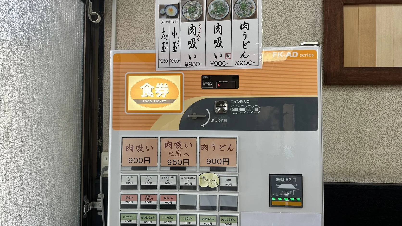 千とせ本店門口的價目表與食券機，肉吸い900円、肉吸い豆腐入950円、肉うどん900円，以及小玉與大玉的價格