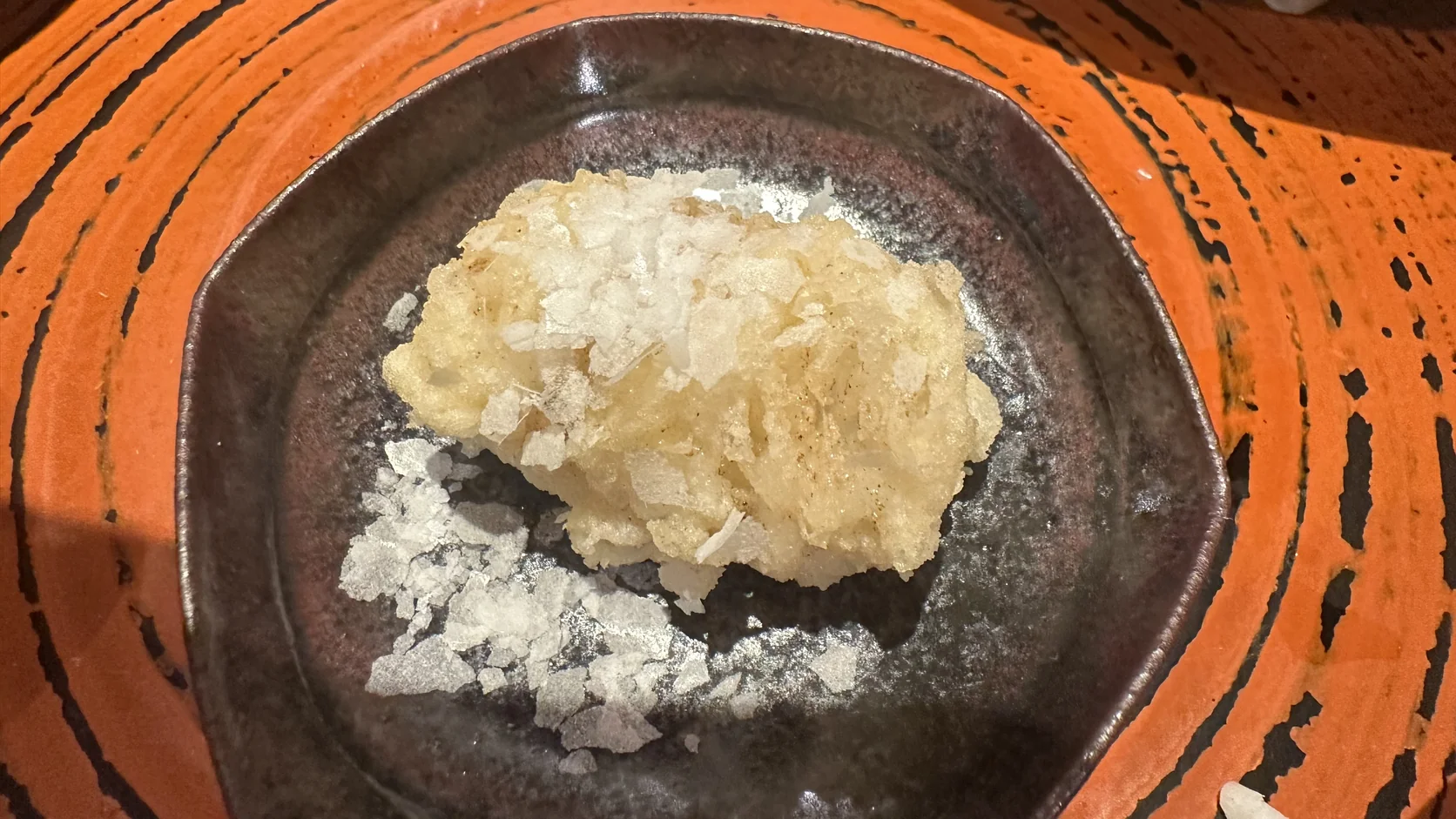 外觀一層層像菇類皺褶的鱧魚天婦羅，表面撒著片狀鹽