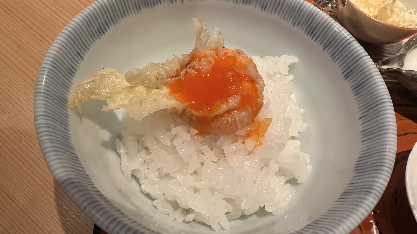 白飯上的雞蛋黃天婦羅，蛋黃流出的橘紅色蛋液
