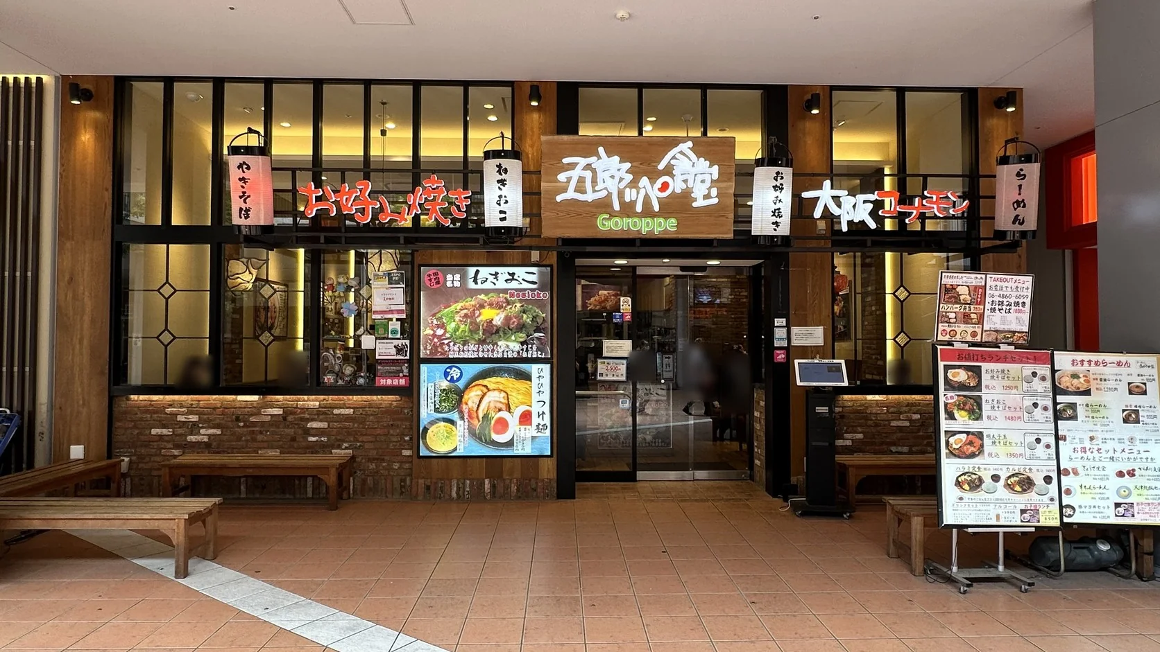 五郎食堂 EXPOCITY 分店的店門口，木質招牌與白色燈籠下方寫著「お好み焼き」「ねぎおこ」「大阪コナモン」，右側立著套餐菜單與 EPARK 候位機